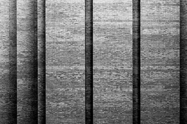 Abstract black and white textured brick wall background with a shallow depth of field.