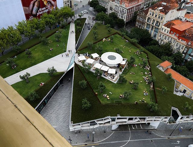 Aerial view of a green rooftop park in the city with people relaxing and enjoying the urban space.
