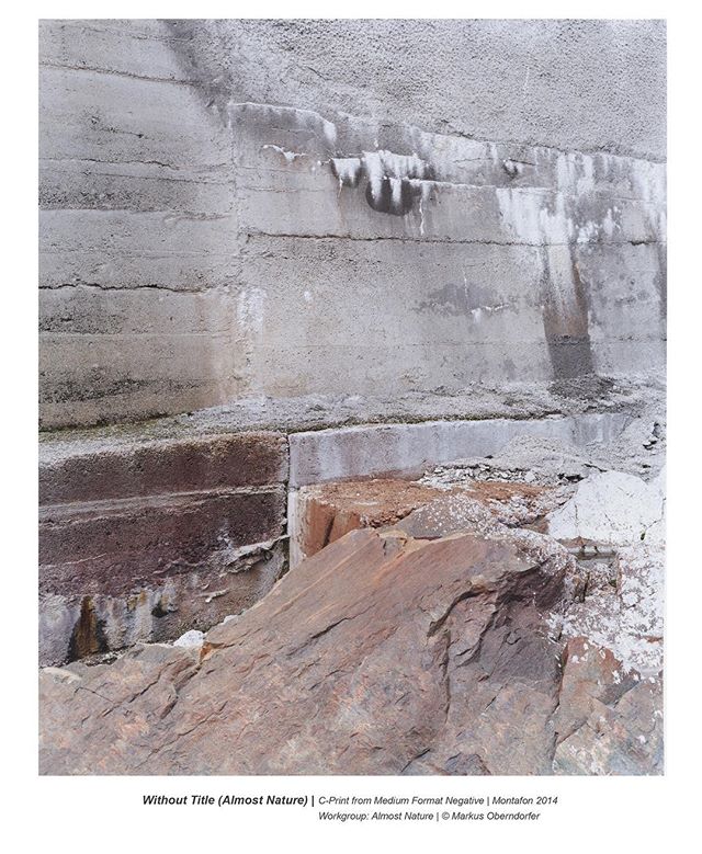 An abstract image of a concrete wall meeting a rocky outcrop in muted earth tones.