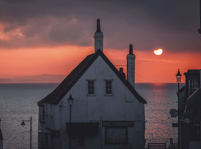 Scenic sunset view of a building by the ocean, with soft lighting and warm tones creating a tranquil atmosphere.