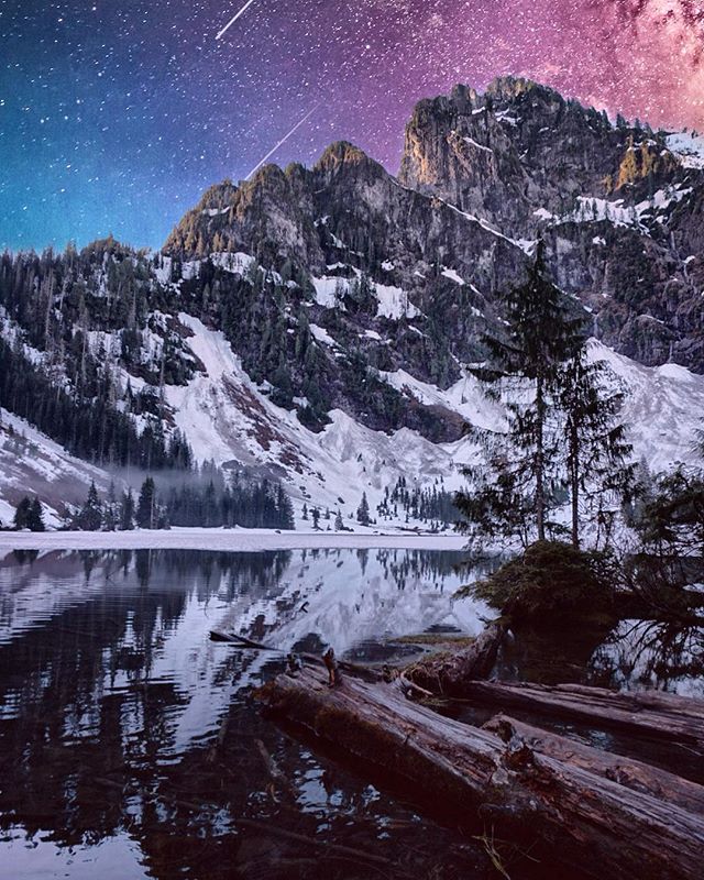 A serene mountain lake reflects the starry night sky and snow-covered peaks, creating a tranquil and breathtaking landscape.