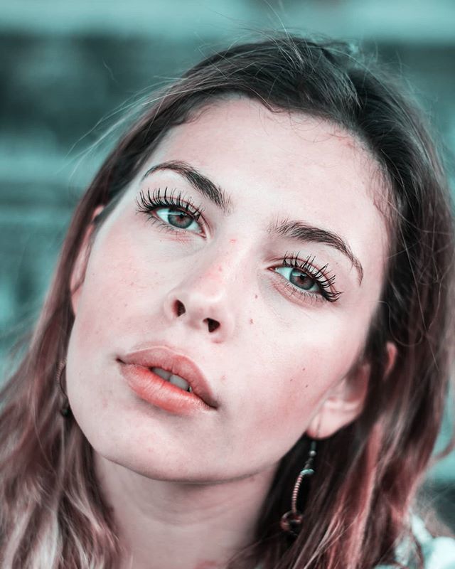 Portrait of a young woman with natural makeup, posing outdoors in soft lighting. Ideal for beauty or skincare campaigns.