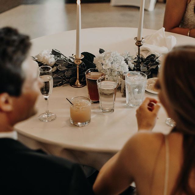 Celebration table setting with drinks, flowers and candles for an elegant wedding event.