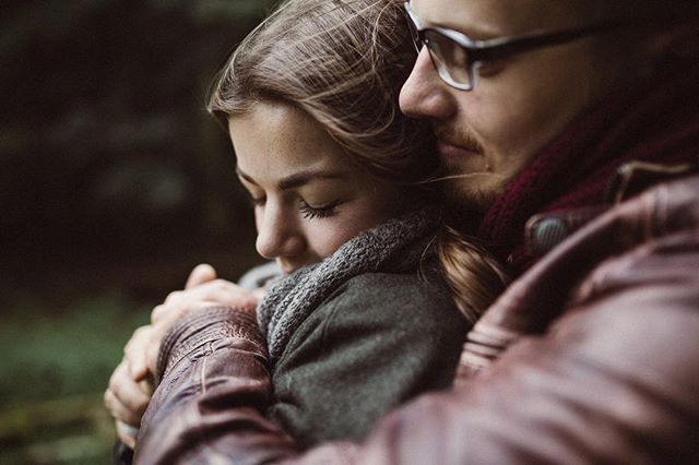 A couple embraces in a tender moment, showcasing love and affection in a natural setting.