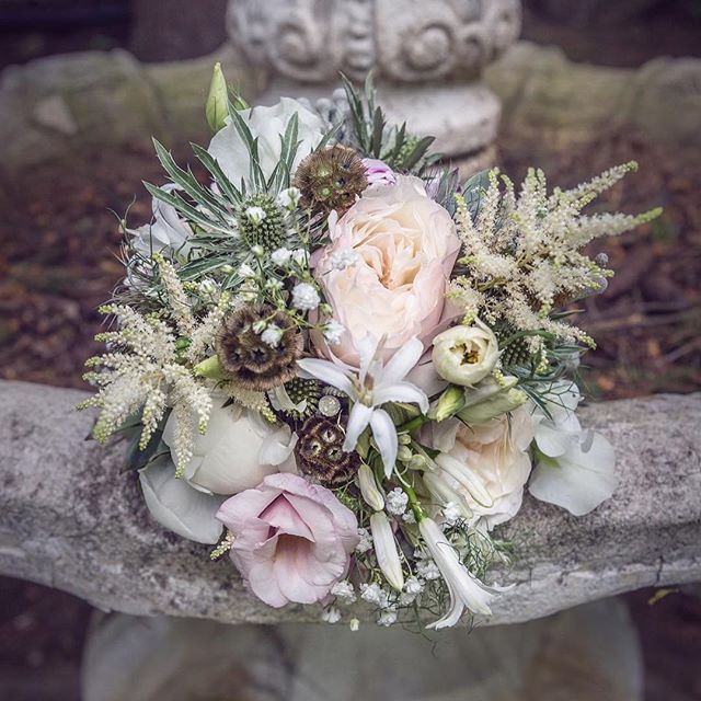 A beautiful bouquet of roses and flowers, perfect for a romantic wedding or special occasion, on a stone surface.