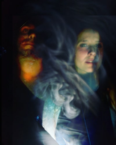 An artistic portrait of a woman and a man, with a dreamy and mysterious atmosphere.