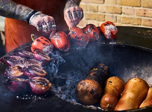 A chef grills peppers and onions on an outdoor barbecue for a fresh, healthy meal.