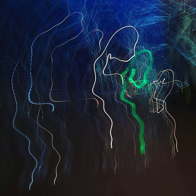 Abstract image featuring vibrant light trails against a dark, blurred background.