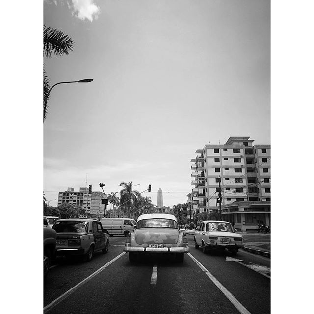 A black and white shot of vintage cars on a street in Havana, Cuba.
