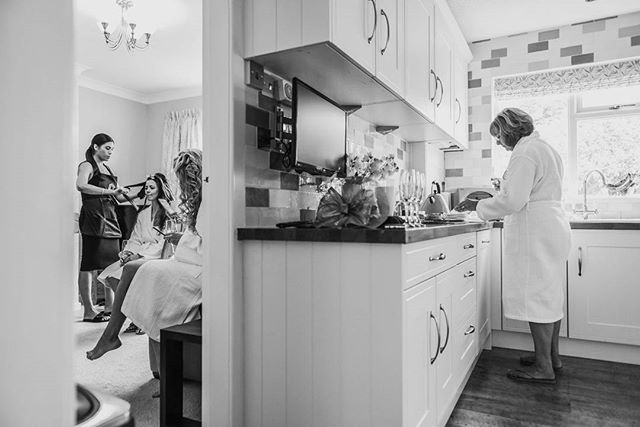 A bride prepares for her wedding day with her stylist in an intimate, classic monochrome setting.