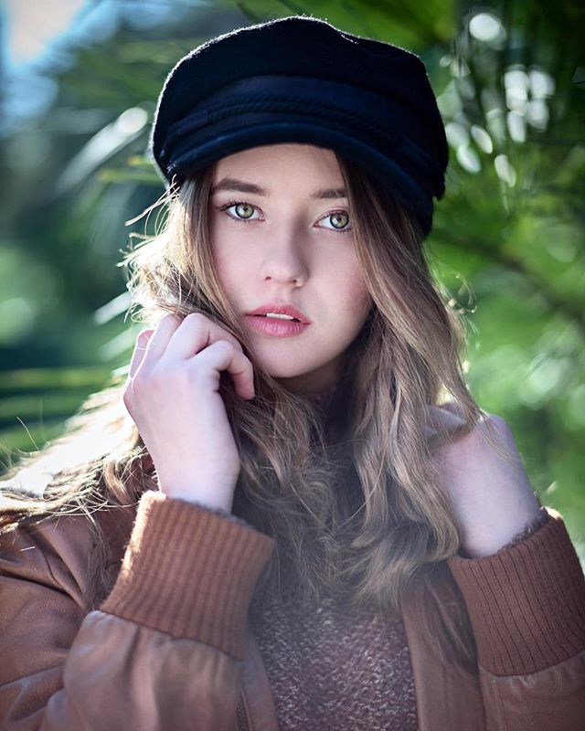 Portrait of a young woman with a hat, posing in soft, natural light. Ideal for beauty and fashion campaigns.