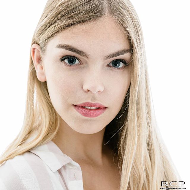 Portrait of a young woman with blonde hair in a studio setting. 