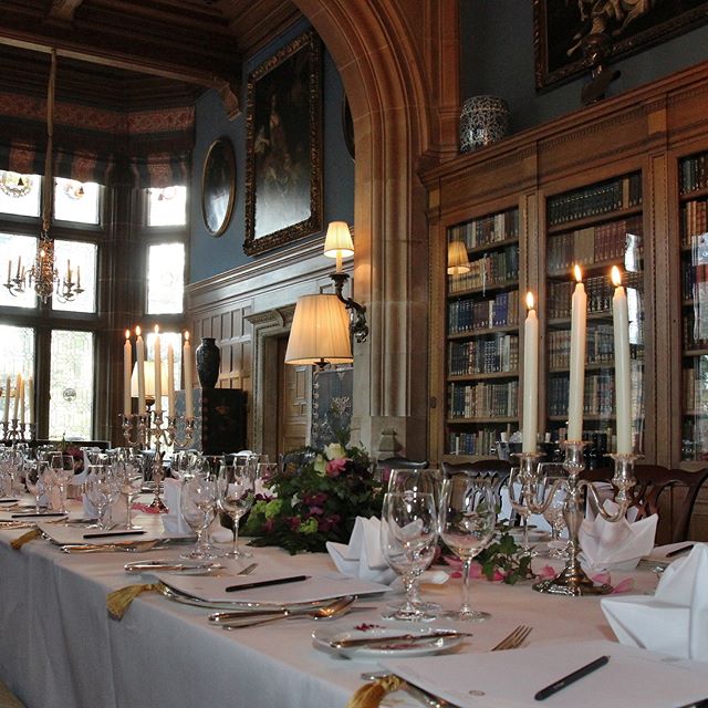 An elegantly set long table with candles and flowers in a classic dining room. Ready for a special event.