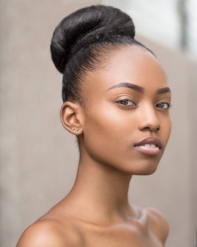 Elegant portrait of a woman with a sophisticated bun hairstyle, showcasing a clean and confident aesthetic.