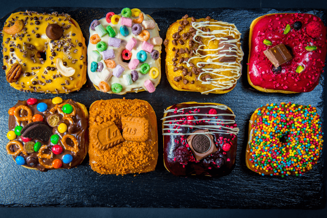 A vibrant assortment of gourmet donuts with colorful toppings, perfect for social media or food blog.