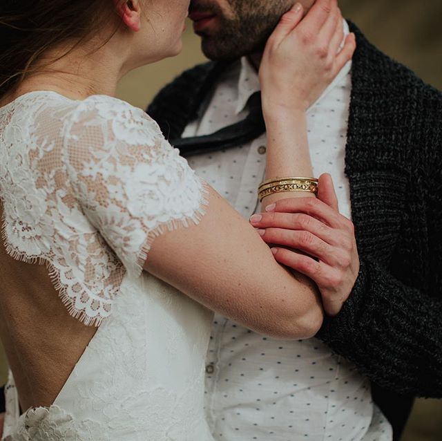 A bride and groom share an intimate moment, embracing, in a soft and romantic outdoor setting on their wedding day.
