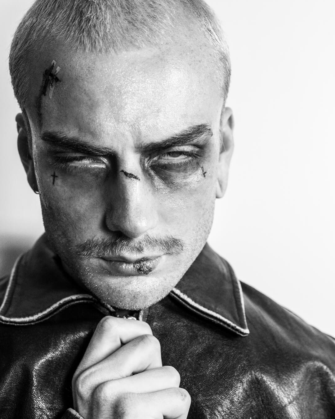 A black and white portrait of a man with wounds in a moody, intense style.