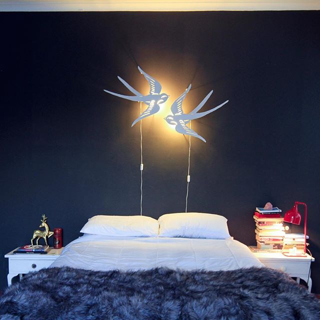 A cozy bedroom features a comfortable bed and unique bedside lamp decor, creating a relaxing and inviting atmosphere.