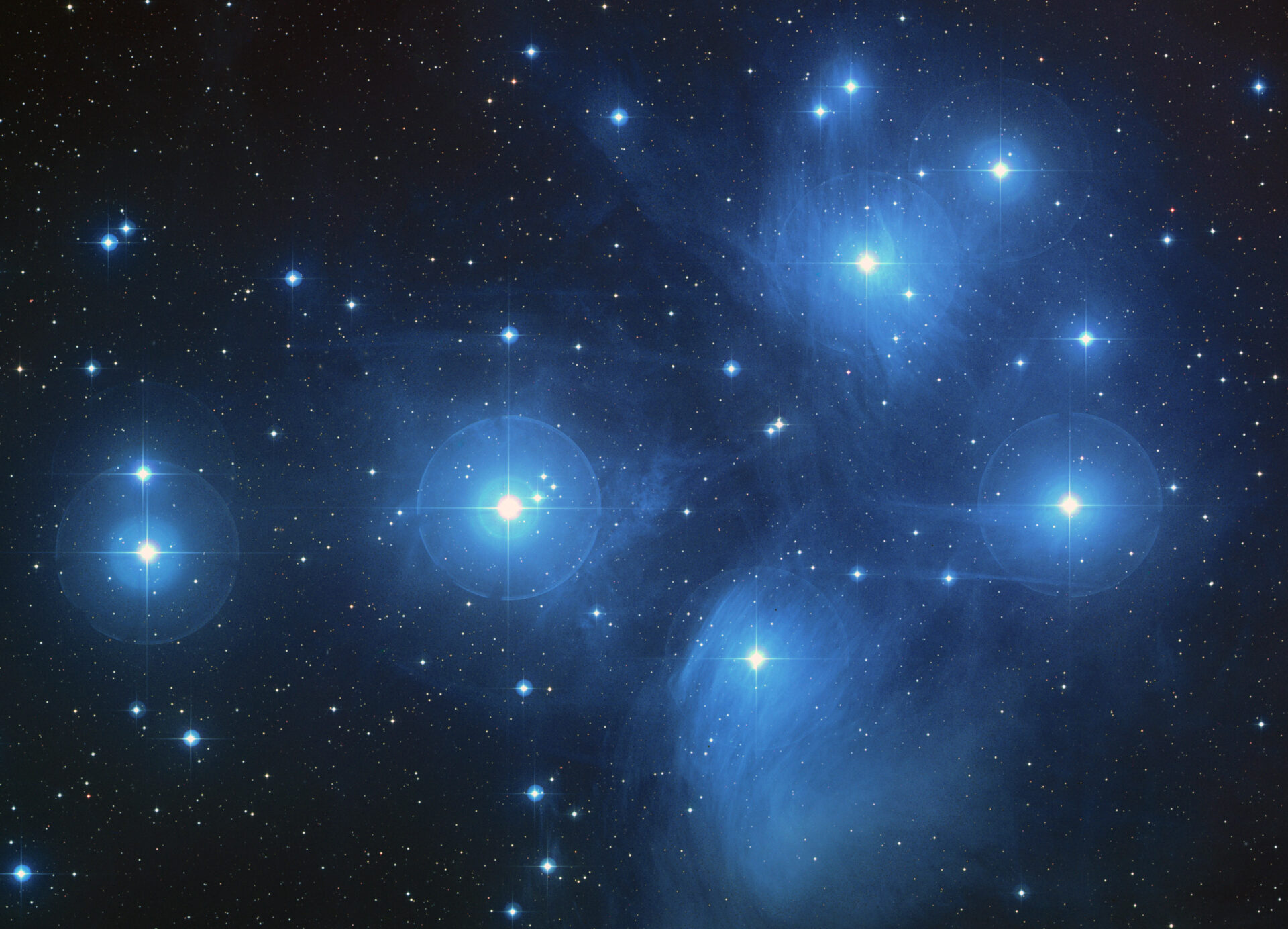 A starscape showing the Pleiades constellation in the night sky