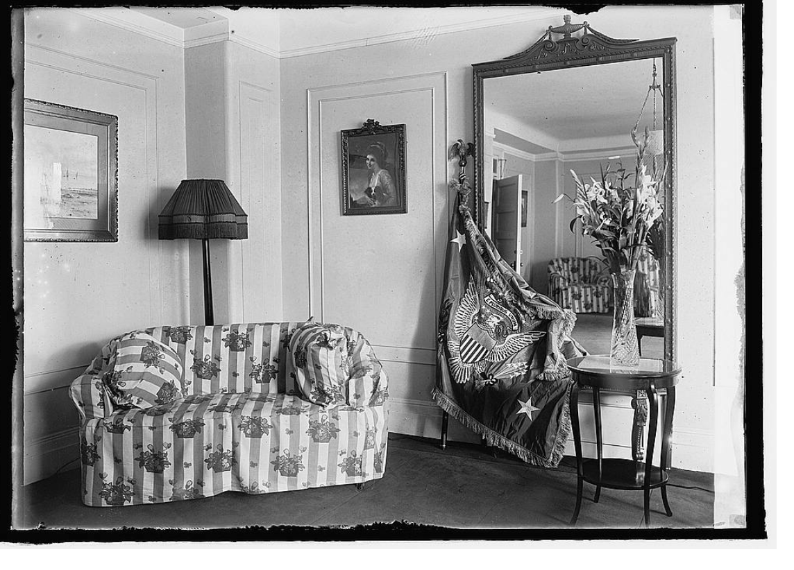 black-and-white 1923 living room with striped sofa and full-length mirror