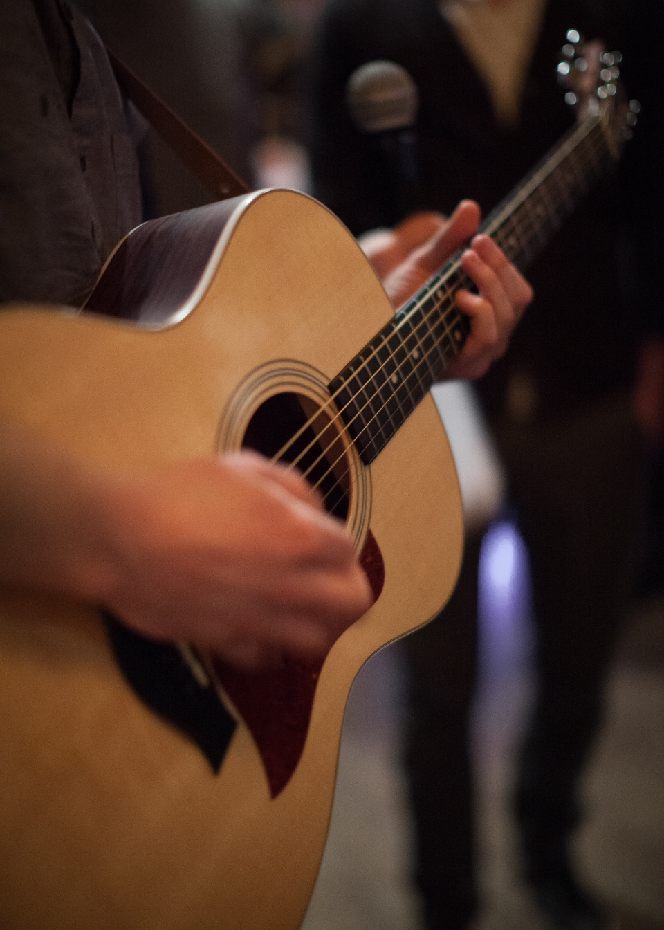 Close-up of a person's hands playing an acoustic guitar