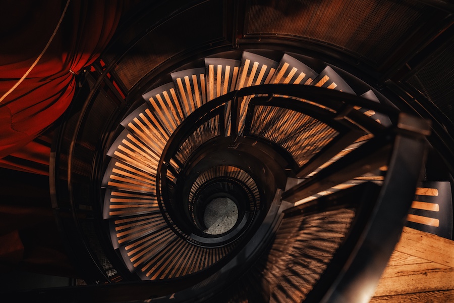 A spiral staircase with wooden steps and a metal railing