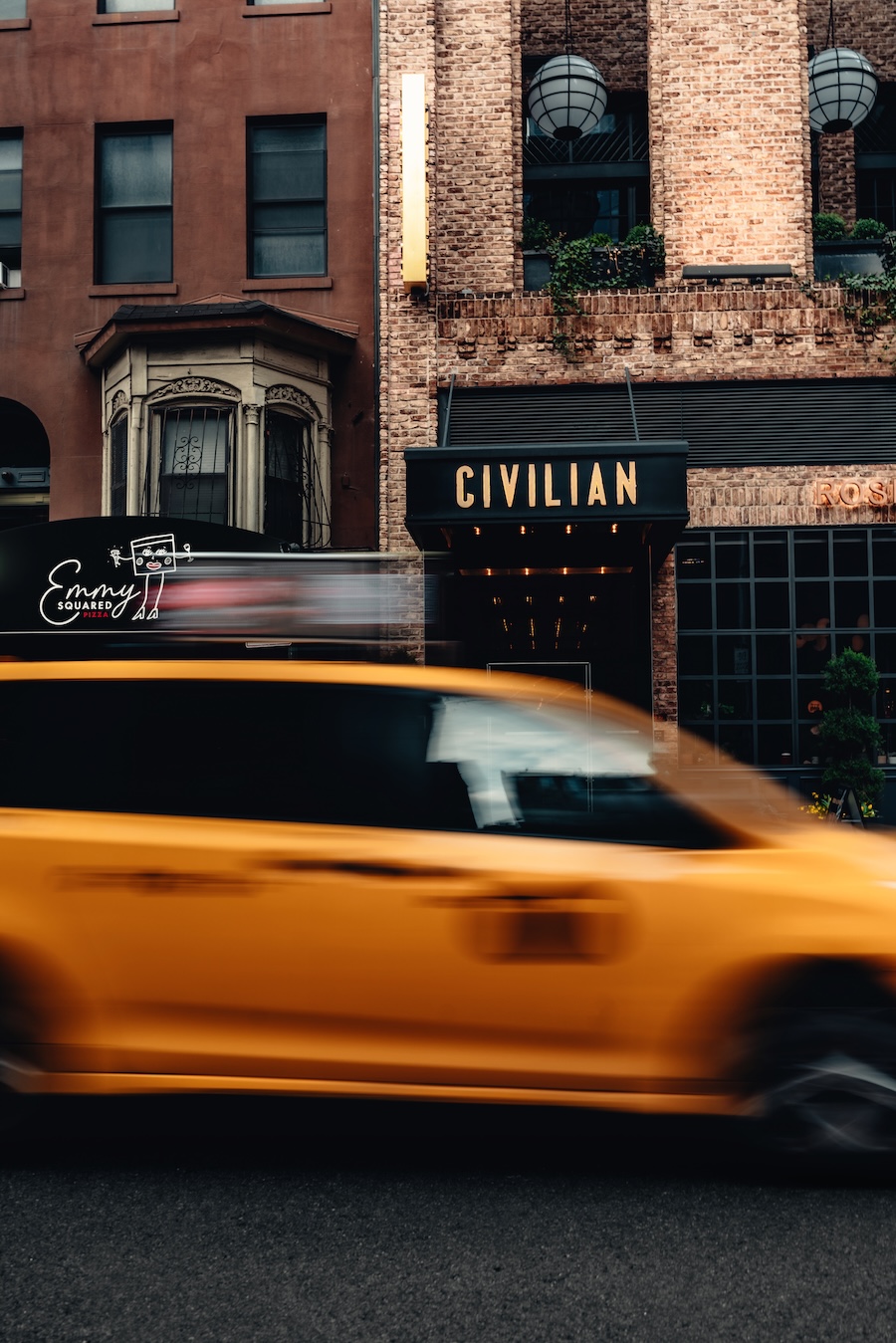 A brick building with a black awning reading 'CIVILIAN' above a storefront