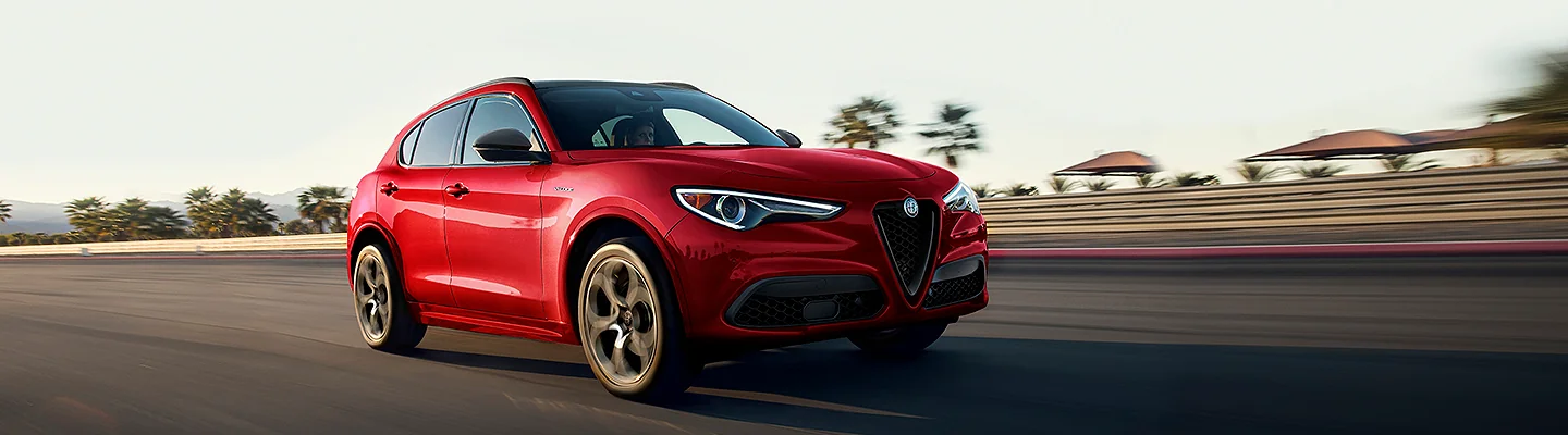 Front view of a red Alfa Romeo driving on track