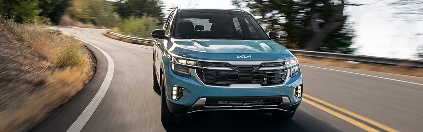 Front view of a 2025 Kia Seltos Denim driving on a road