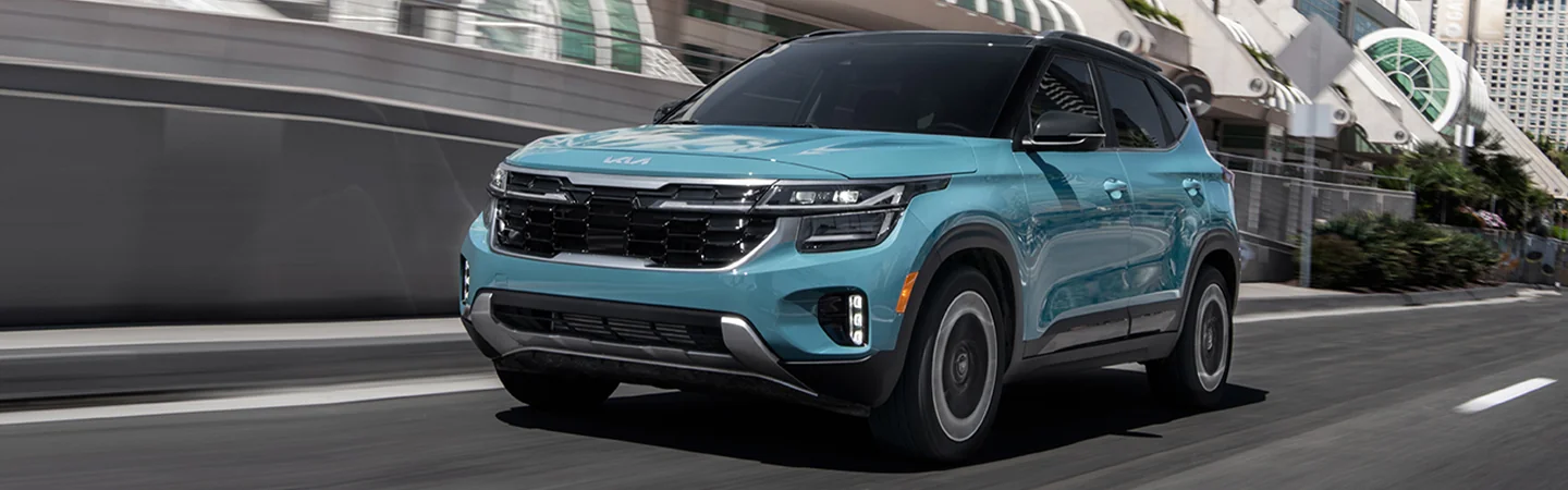 Side view of a 2025 Kia Seltos Denim driving in the city