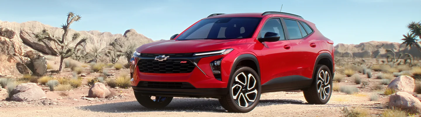 A red 2025 Chevrolet Trax parked in a rocky part if the desert