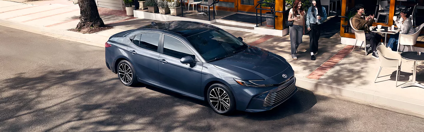 2026 Toyota Camry parked in front of a city cafe in the daytime