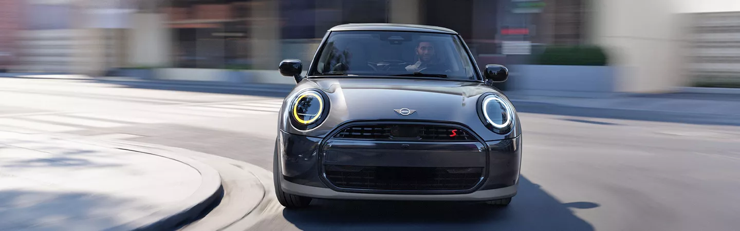 Front view of the 2026 MINI Cooper 2-Door driving through the city