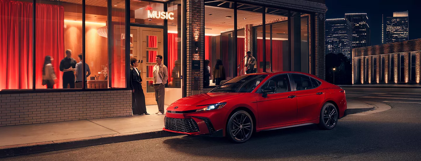 2026 Toyota Camry parked in front of a restaurant in the city