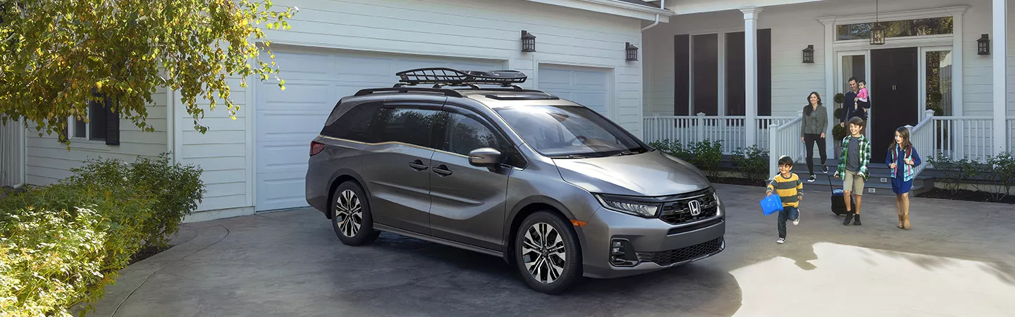 2026 Honda Odyssey parked at a home with the family getting read to go on a road trip
