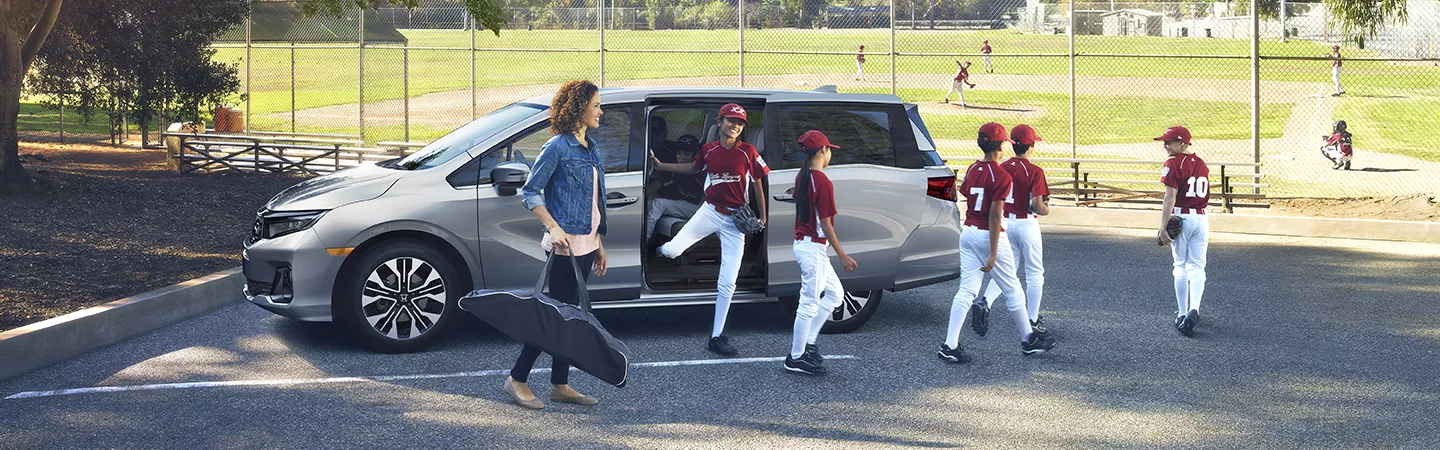 2026 Honda Odyssey parked at a baseball field with kids walking toward the field