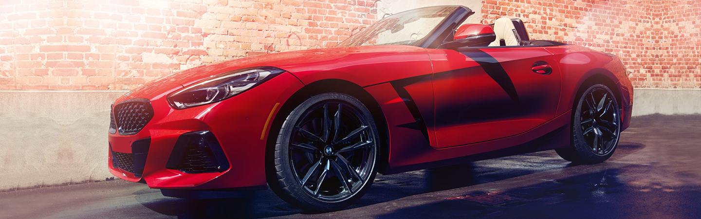 Red 2022 BMW Z4 parked by a brick wall