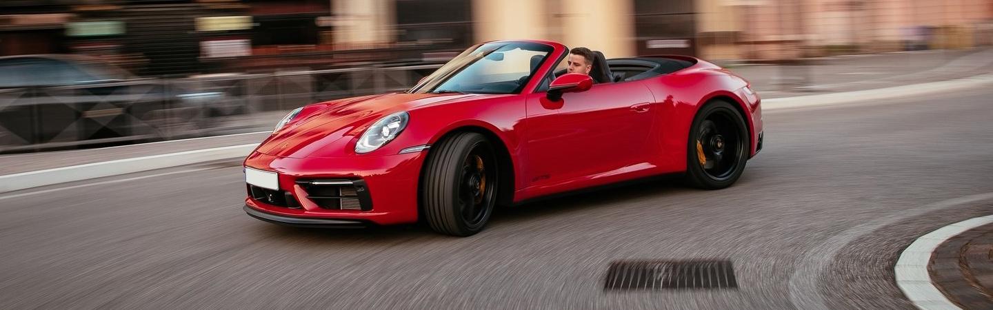 Red 2022 Porsche 911 Convertible driving in city