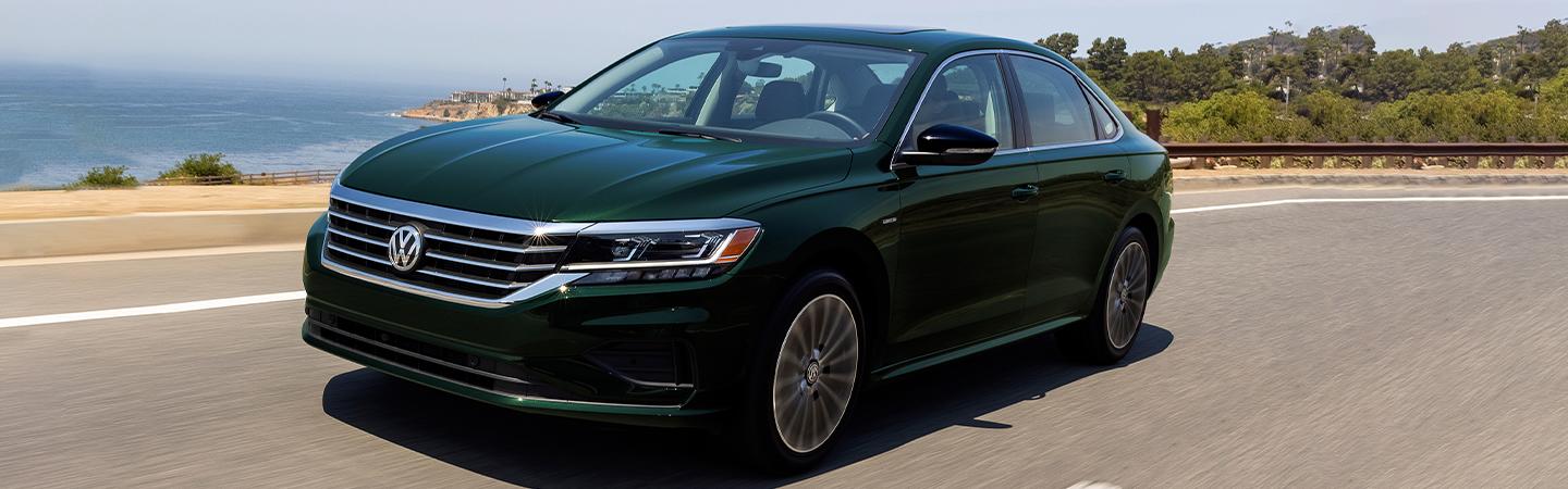 Green 2022 Volkswagen Passat driving next to the ocean