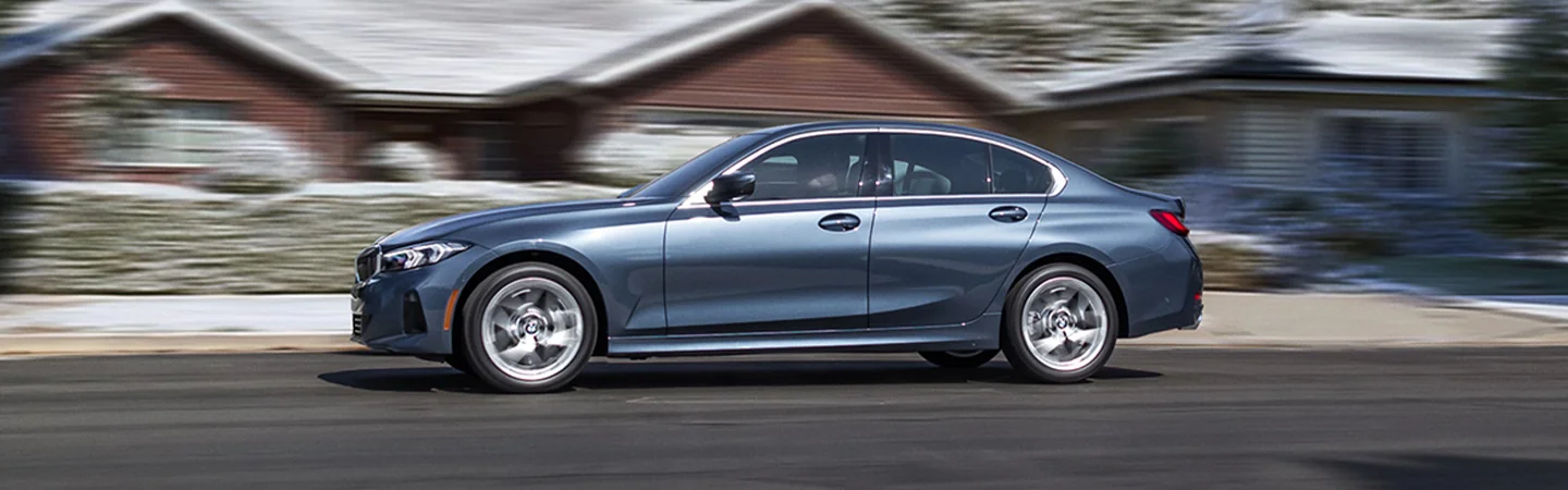 driver side view of a blue 2026 BMW 3 Series 330i in motion
