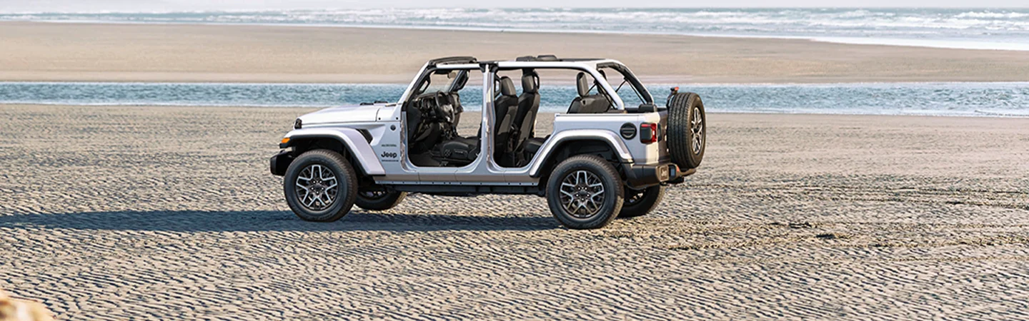a white 2026 Jeep Wrangler Sport driving on lake bed