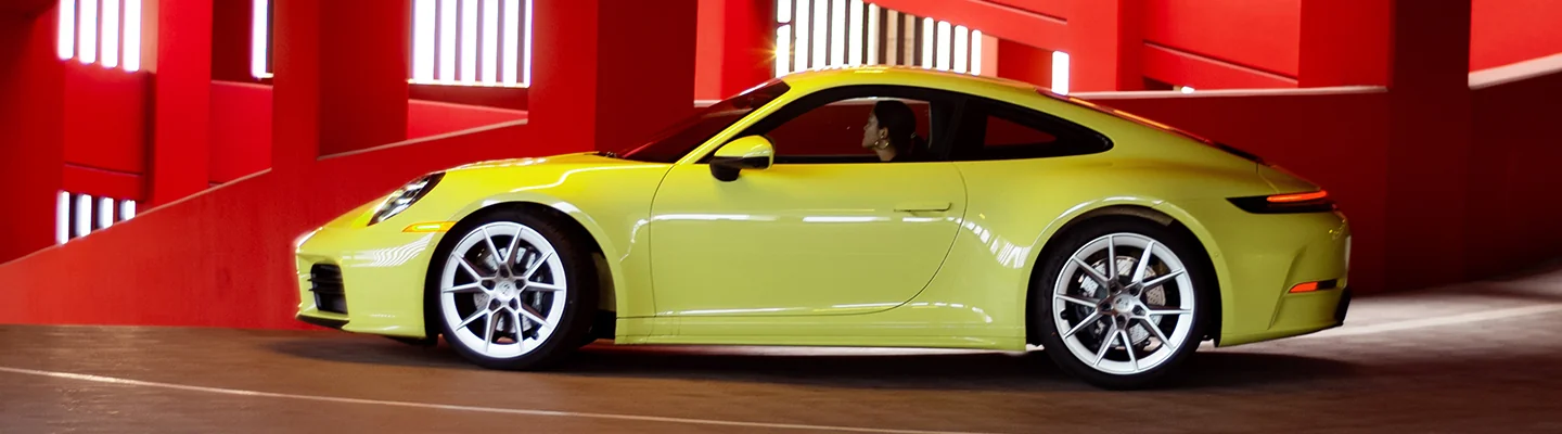 driver side view of a a bright yellow Porsche