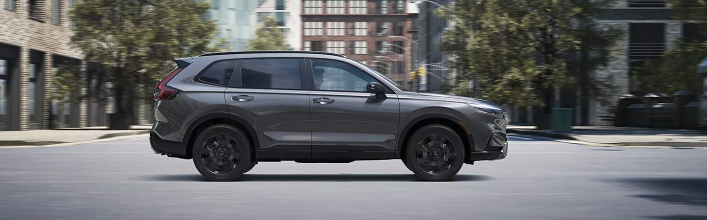 Side view of the 2026 Honda CR-V driving through the city during the daytime