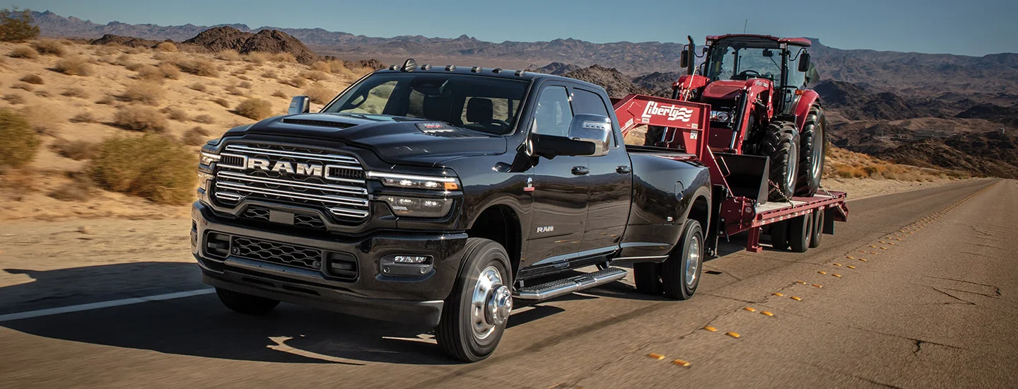 Front view of a black 2026 RAM 3500 pulling a trailer