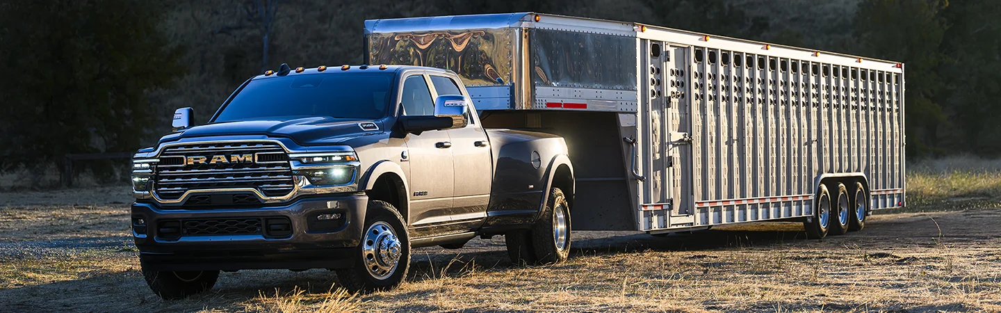 Front view of a gray parked 2026 RAM 3500 with a trailer