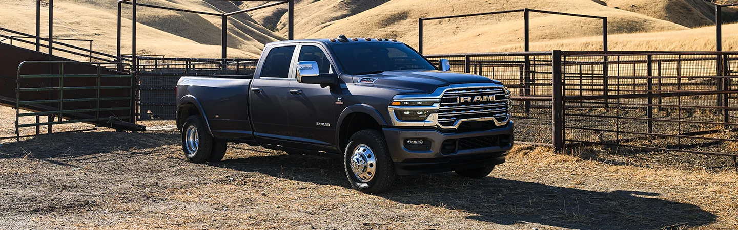 Front side view of a gray 2026 RAM 3500 parked at a farm