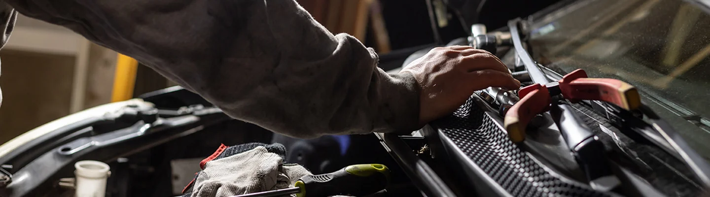 Service tech working on an engine of a Porsche