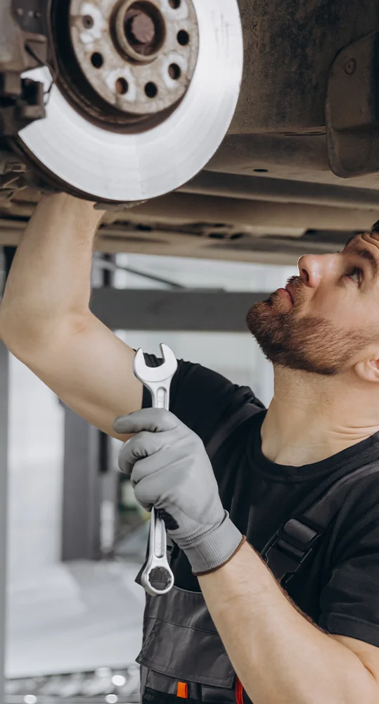 car mechanic working on car on ta lift