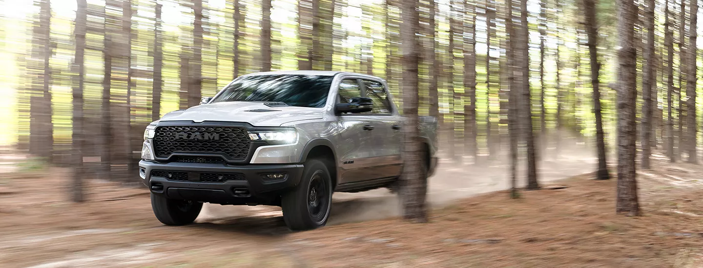 2026 RAM 1500 driving through the woods