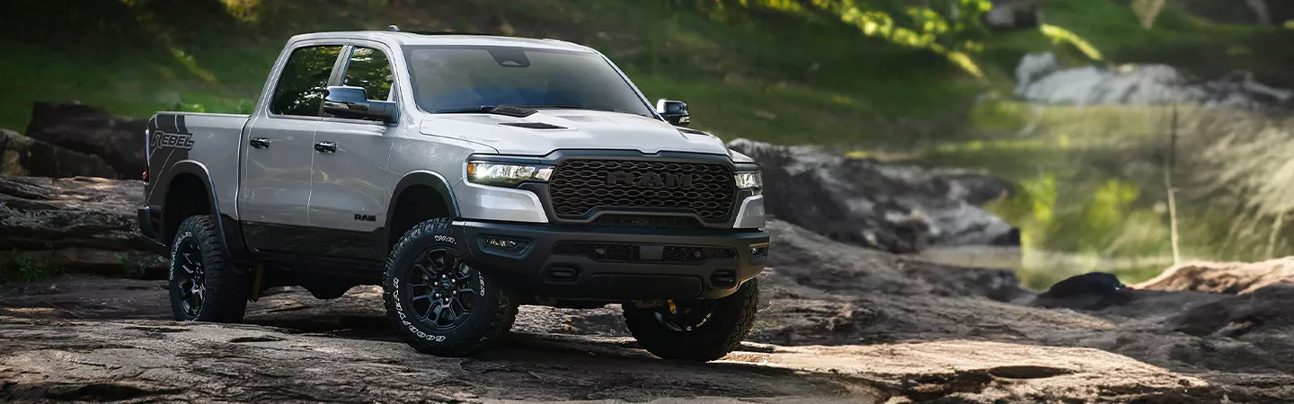 2026 RAM 1500 parked on rocks with the forest in the background